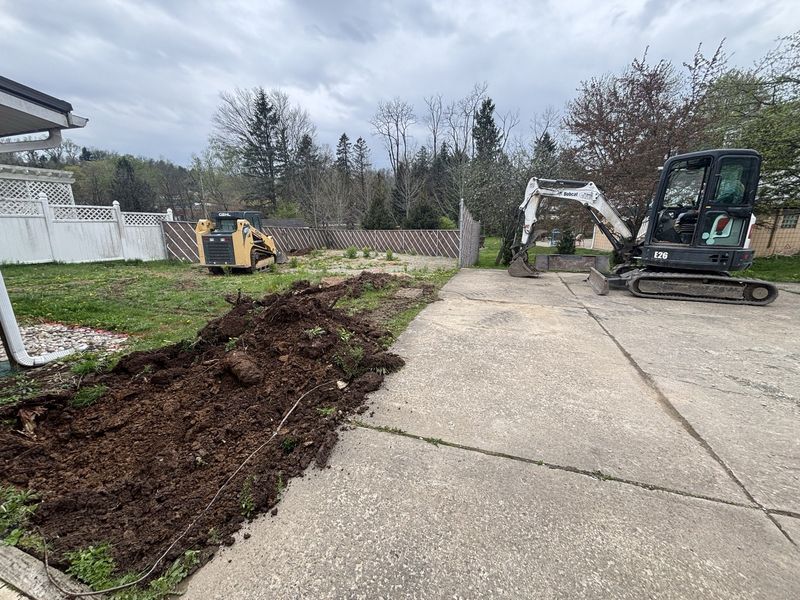 Concrete driveway tear-out with Bobcat E26 excavator and Gehl track loader on site