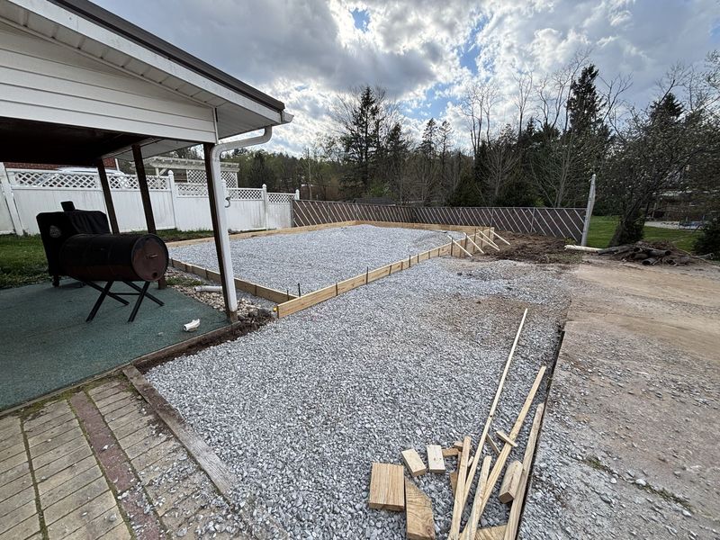 Compacted gravel base with wood forms prepped for garage foundation concrete pour